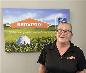 A female SERVPRO employee is shown in a black shirt with SERVPRO logo