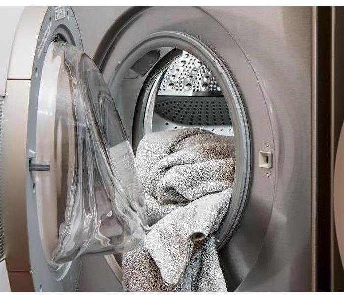 Machine Washer with door open and towel hanging out