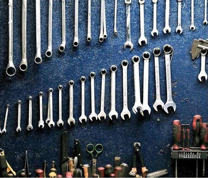Tools are shown hanging on the wall of a garage 