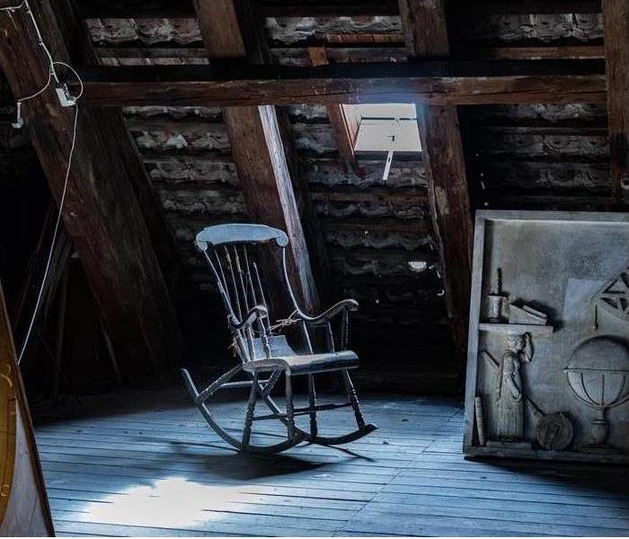 A rocking chair in an attic is shown 